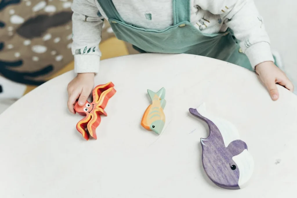 Child playing with colorful wooden toys in a playroom and nursery combo