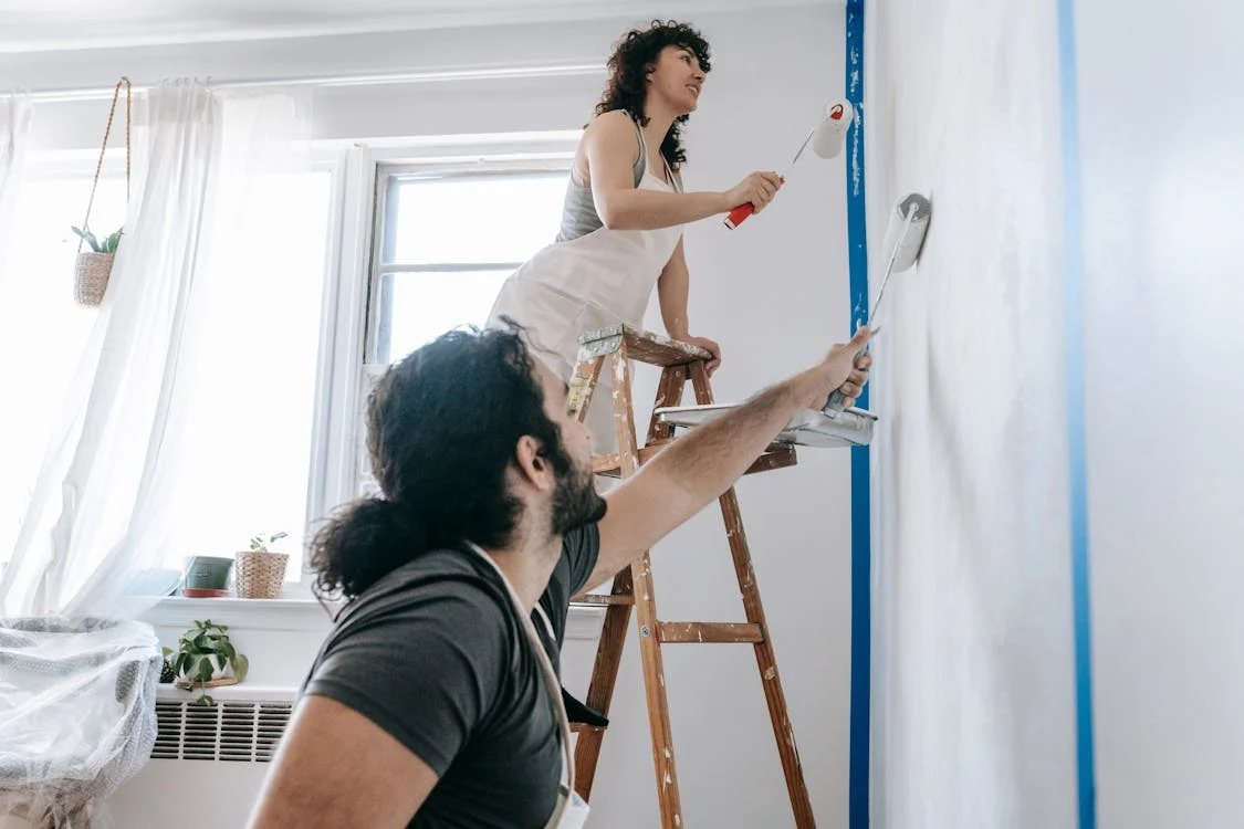 Couple painting a wall during their home remodel

