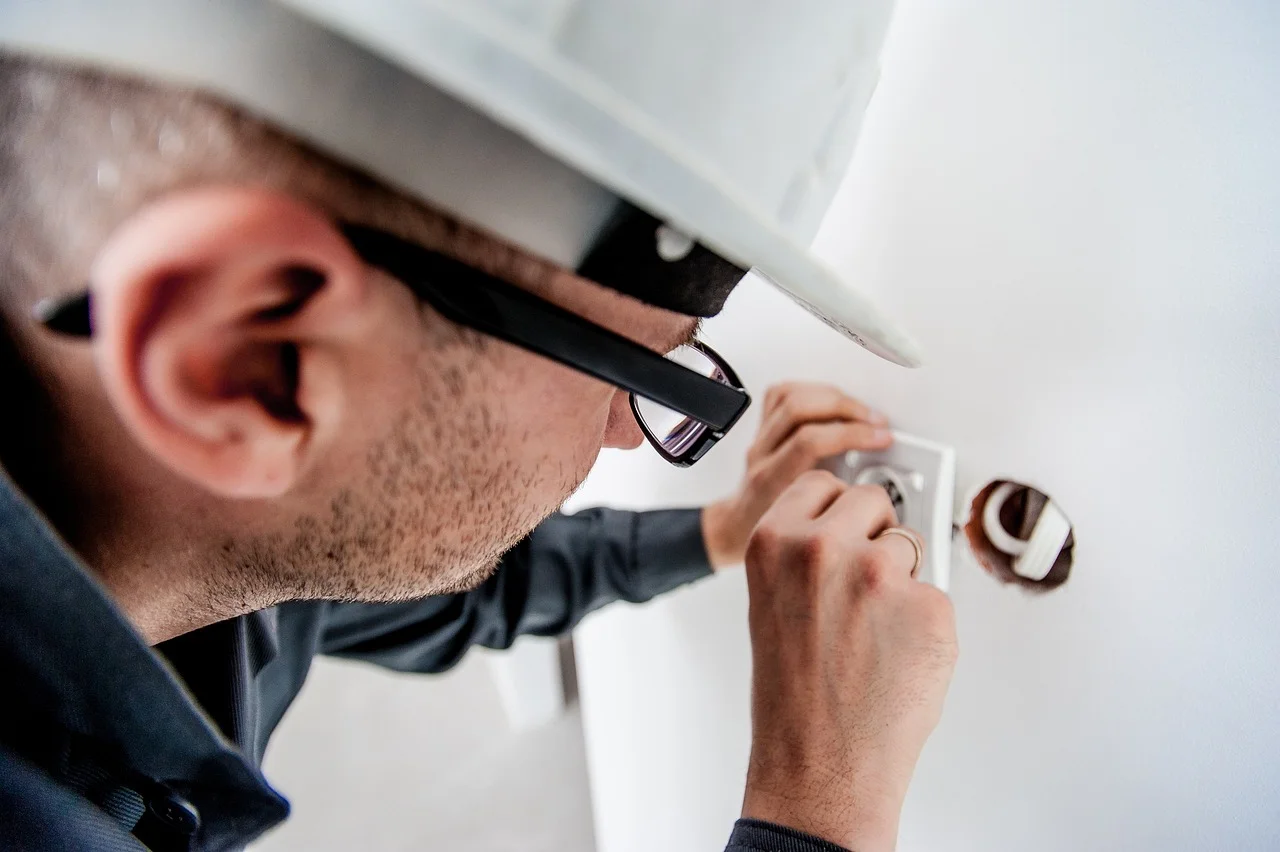 Find the Right Electrician for Your Household Needs With This Guide - Featured - Homedecortoday Electrician repairing electrical panel to ensure home safety and functionality.